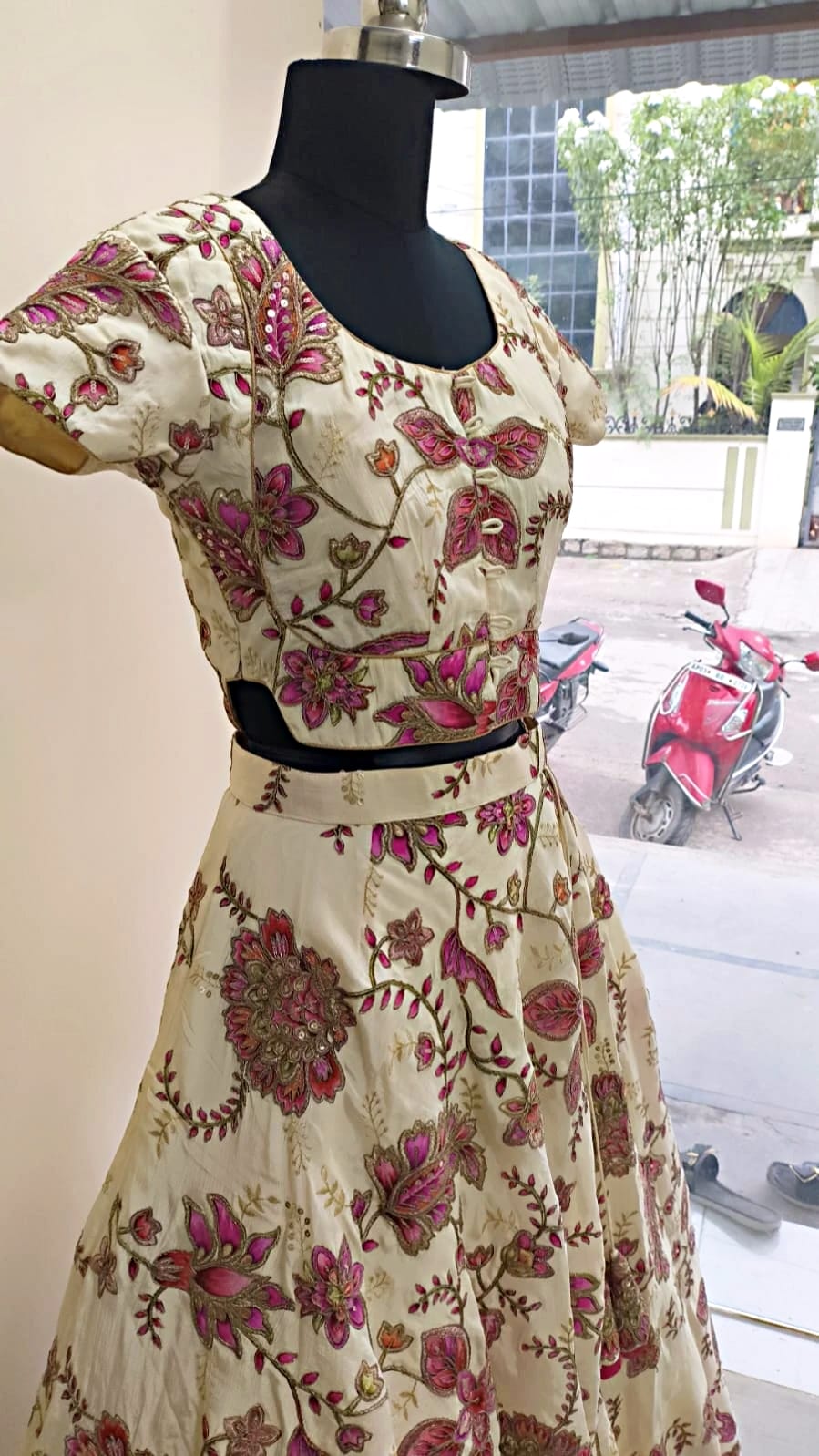 Cream lehenga with floral embroidery on a mannequin
