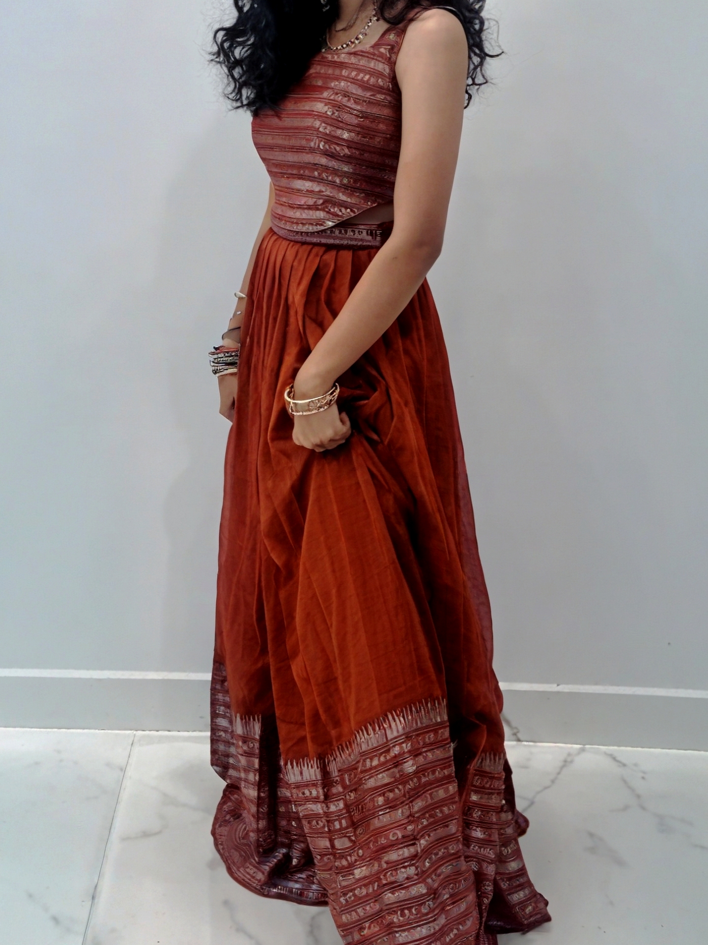 Rust orange lehenga with metallic silver border